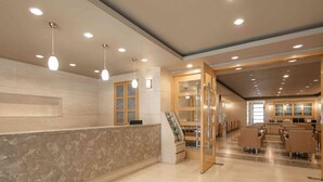 A hotel lobby with a reception desk, seating area, and a staircase leading to upper floors. - Kindness Hotel Han Shen (Kaohsiung)