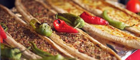 A variety of flatbreads with toppings, including some with red and green peppers.