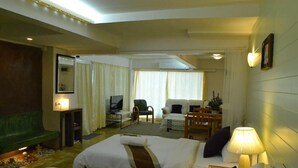 Hotelkamer met twee bedden, een bureau met een computer, een televisie, een bank en een stoel.