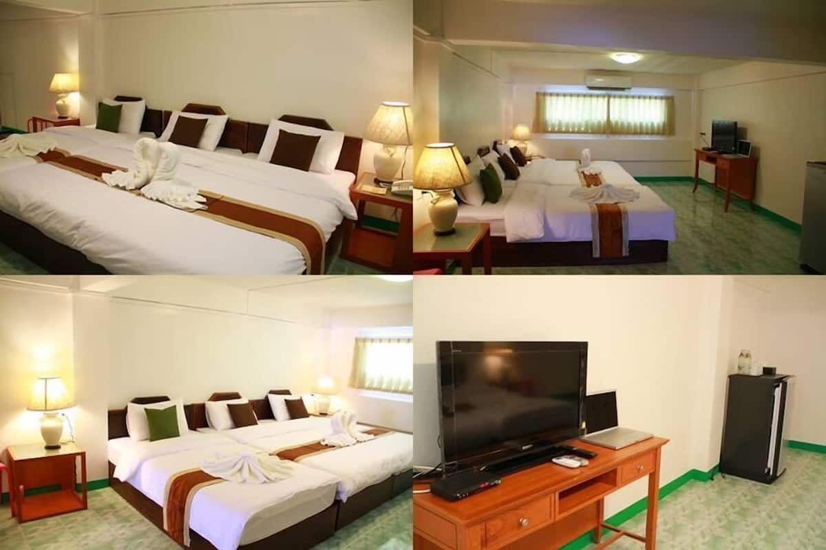 Een hotelkamer met twee bedden, een televisie, een bureau en een koelkast.