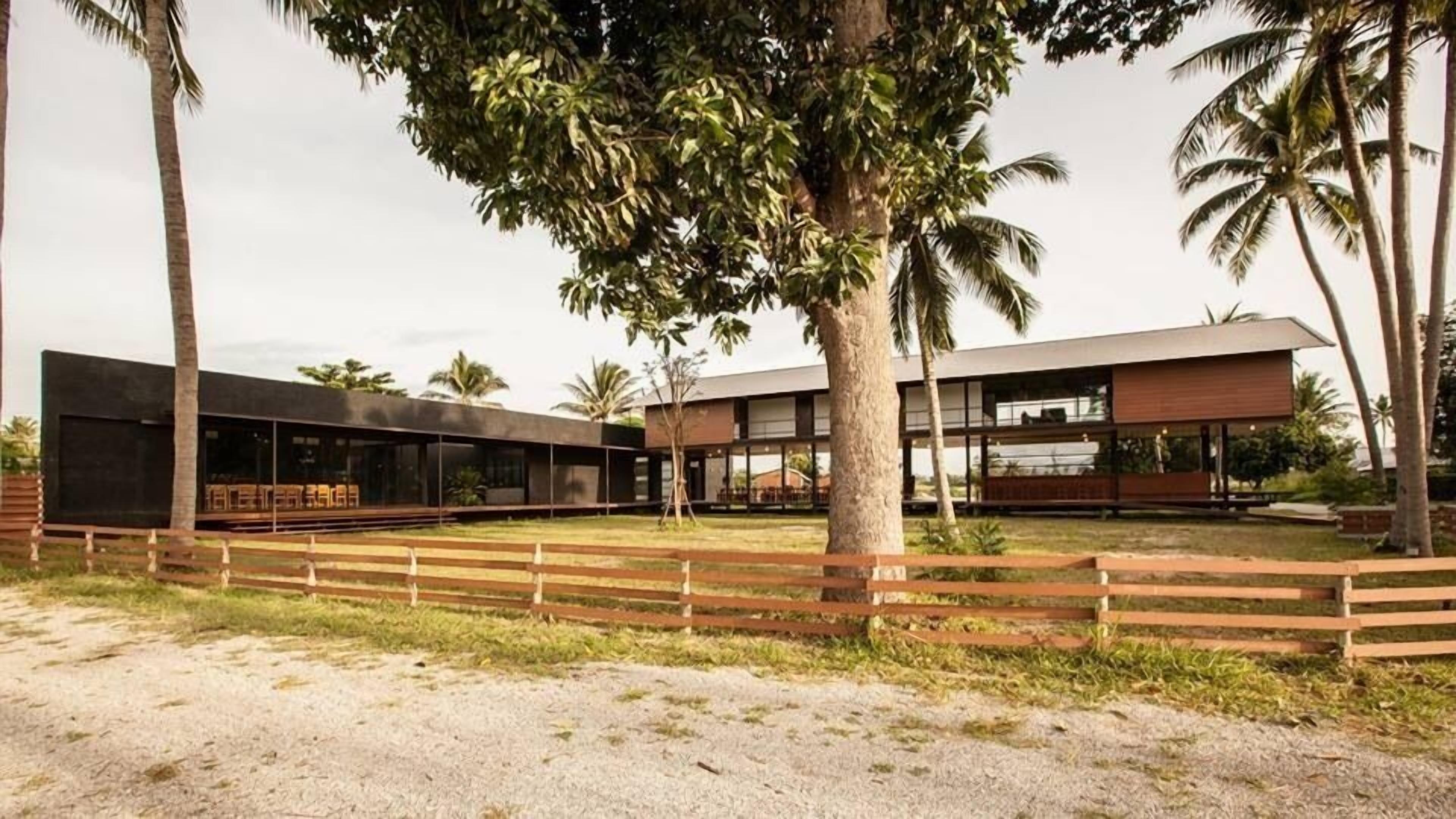 A modern building with large windows and a wooden fence in front.