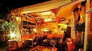 An indoor restaurant with wooden tables and chairs, a bar area, and various plants. - Baan Fern Talay (Cha-am)