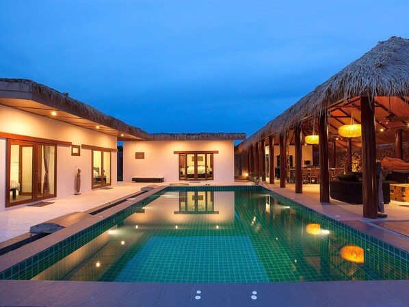Una piscina al aire libre, tumbonas