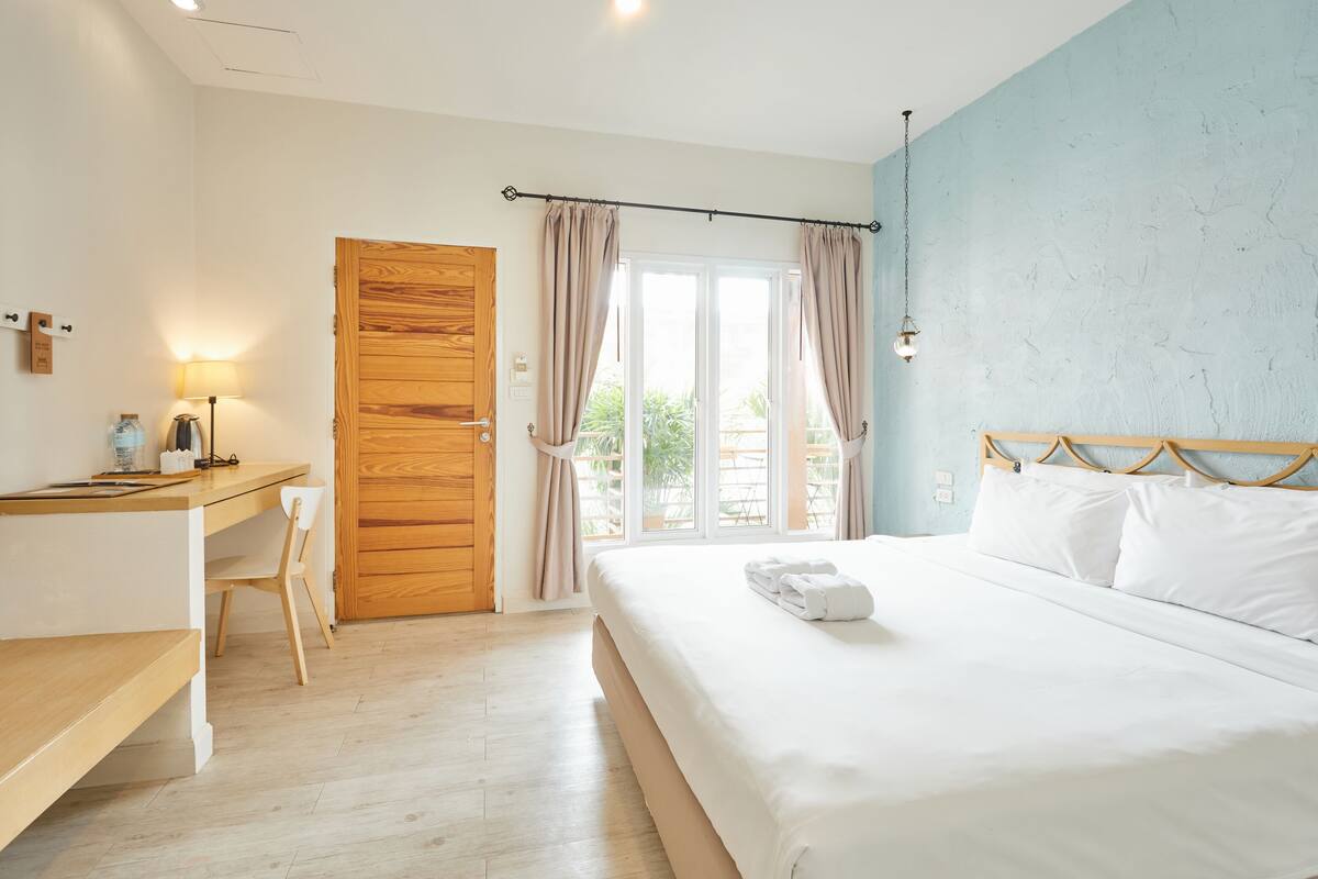 A bedroom with a bed, a desk, and a chair.