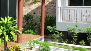 A two-story building with a balcony, a covered patio, and a stone pathway.