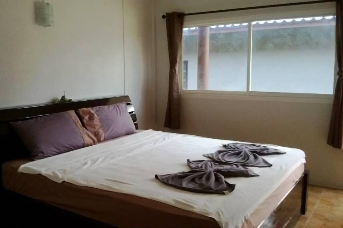 Una habitación de hotel con una cama, una ventana con cortinas y vistas al exterior.