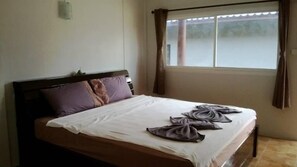 Une chambre d’hôtel avec un lit, une fenêtre avec des rideaux et une vue sur l’extérieur.