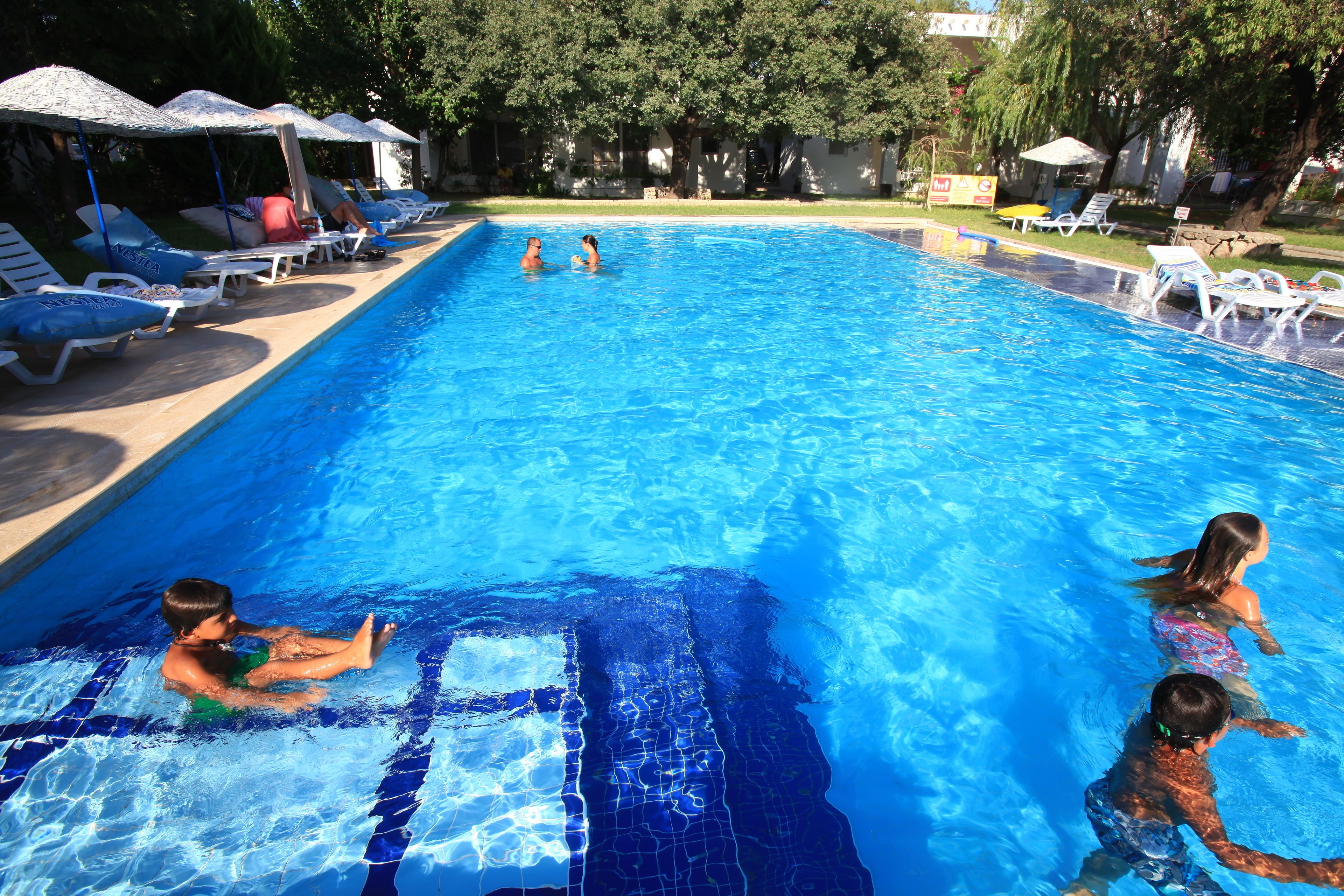 Ein Swimmingpool mit Liegestühlen und Sonnenschirmen.