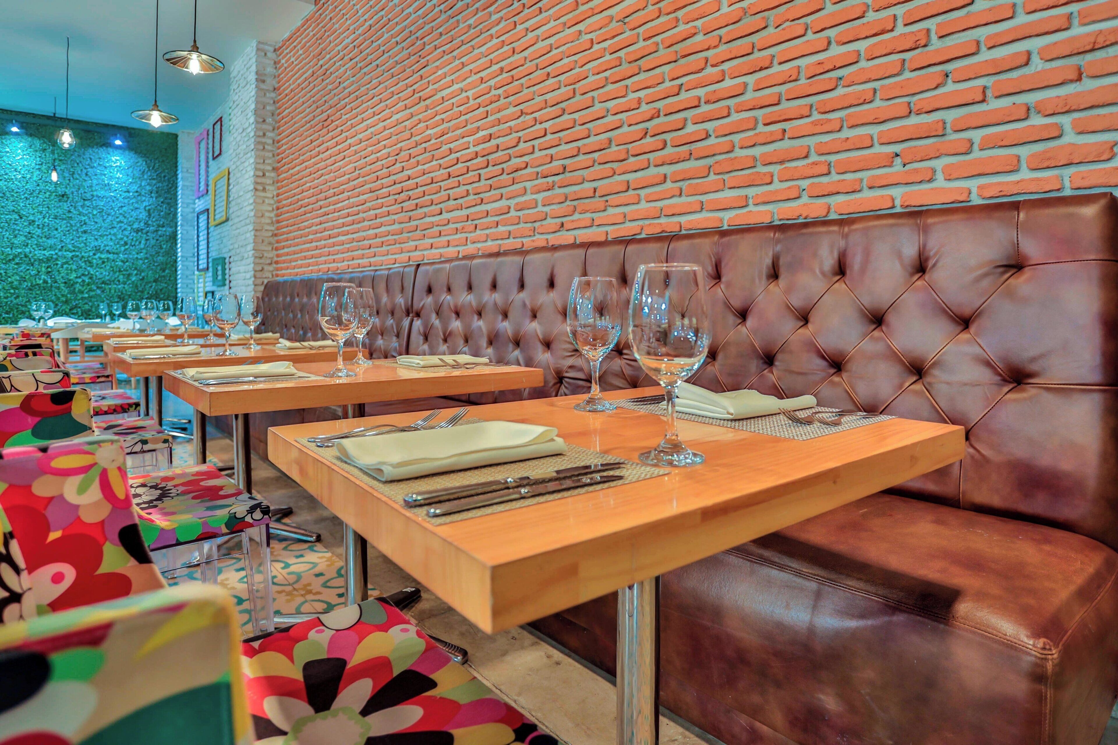 A restaurant with multiple tables and booths, each with neatly set dining ware.