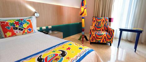 Una habitación de hotel con una cama, una silla, una mesa y una lámpara.