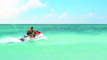 A person riding a jet ski on turquoise water.