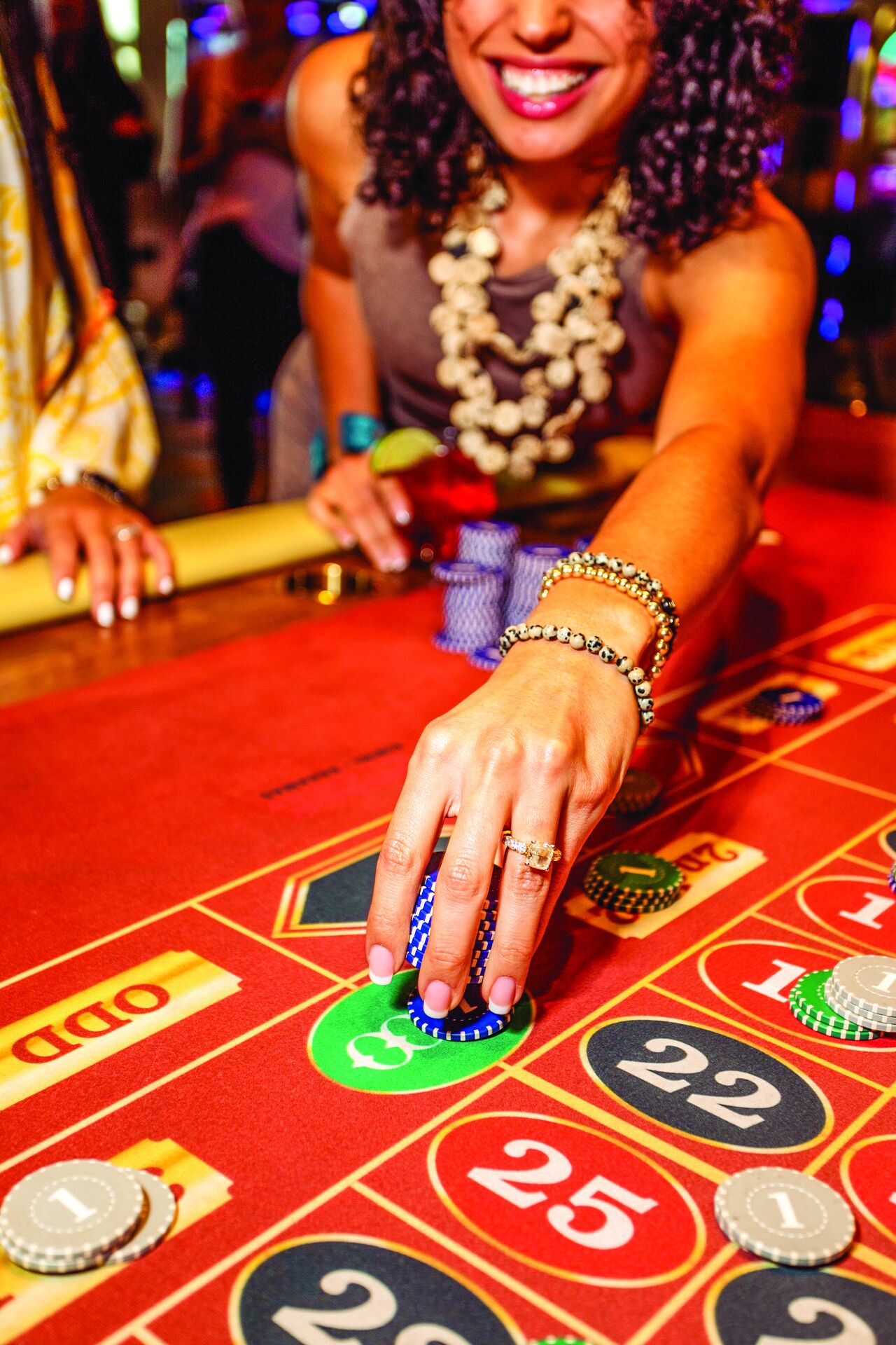 A hand placing chips on a roulette table.