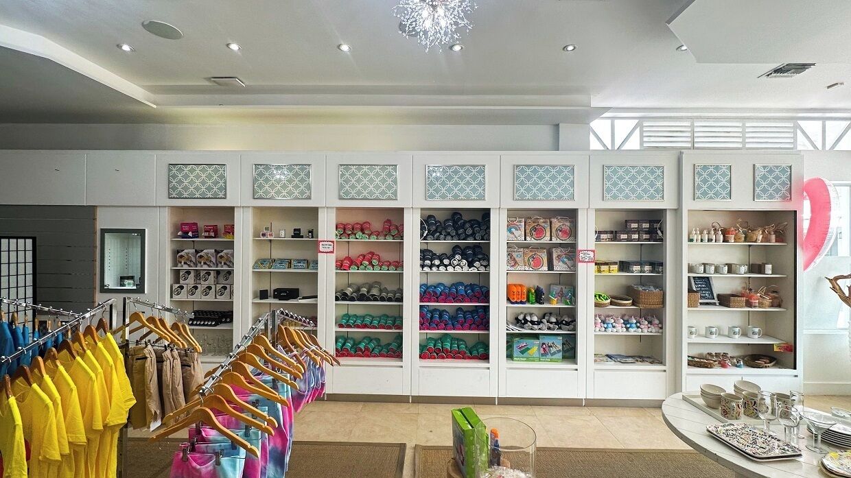 A retail store with shelves of various products, a clothing rack, and a table with items.