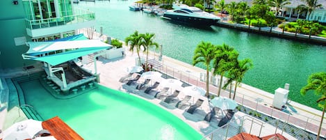Un port de plaisance avec des bateaux, une piscine et des chaises longues.