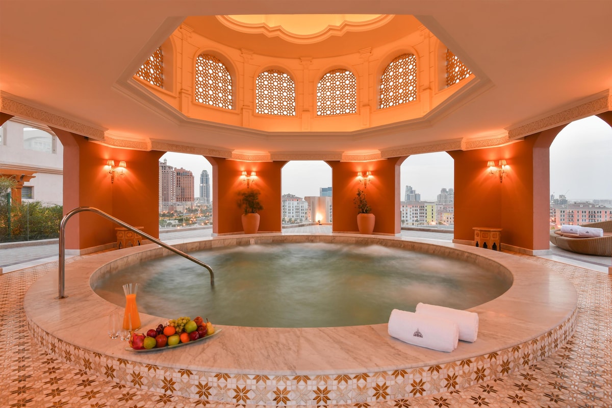 Una piscina al aire libre, sombrillas, sillones reclinables de piscina