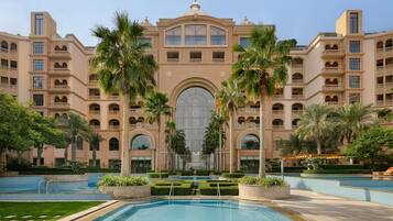 Un grand hôtel doté de nombreux balcons, d’une cour intérieure et d’une piscine.