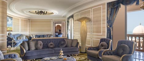 A luxurious living room with a grand chandelier, elegant furniture, and a view of the sea.