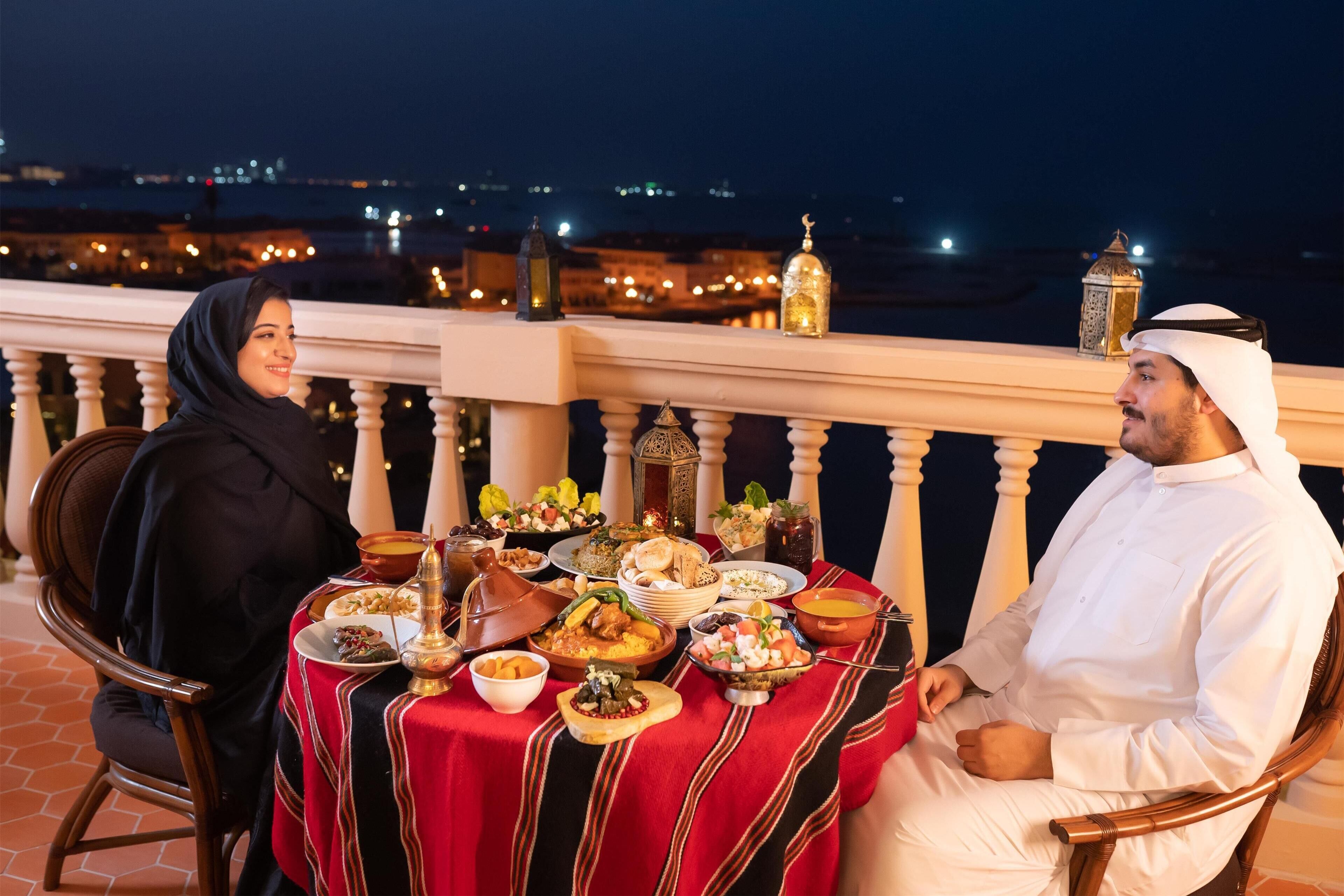 A dining table with a variety of dishes and a cityscape view in the background.