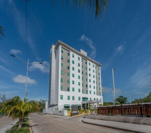 Un hotel moderno con fachada blanca, varias ventanas y tejado plano.