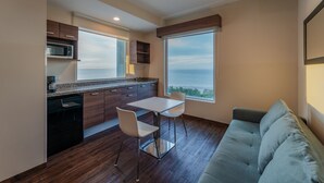 Cocina moderna con comedor, microondas integrado y un amplio ventanal con vistas.