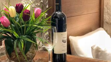 Eine Weinflasche, ein Glas und eine Vase mit Tulpen auf einem Holztisch.