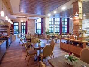 Un restaurante amplio con mobiliario de madera, ventanas grandes y diversas opciones para comer.