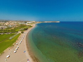 Una playa cerca, sillas reclinables de playa, sombrillas