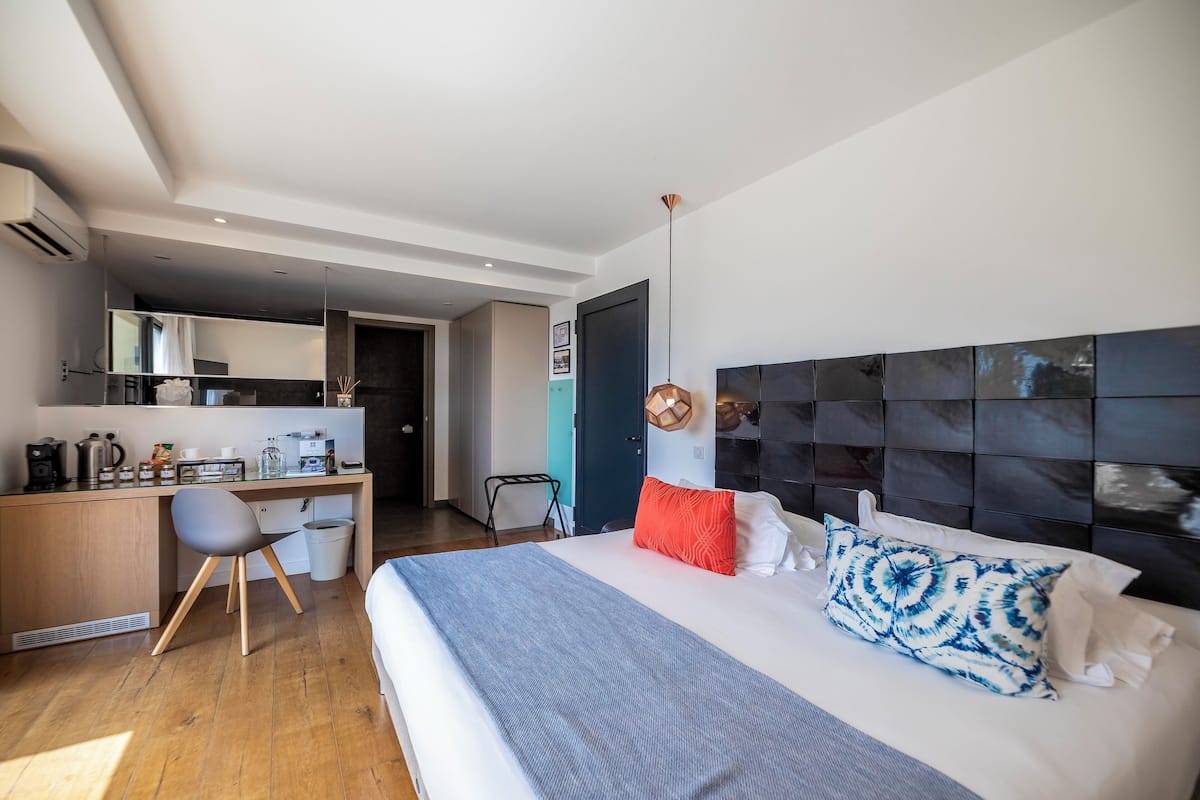 Une chambre d’hôtel moderne équipée d’un grand lit, d’un bureau et d’une kitchenette.