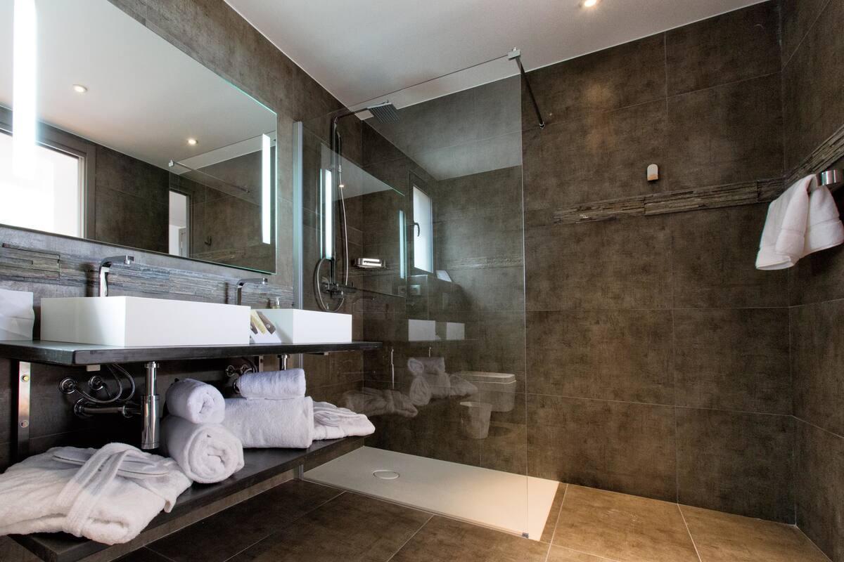 deluxe room | bathroom | shower, free toiletries, hair dryer, slippers