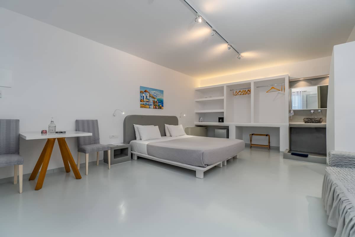 A modern bedroom with a bed, a desk, and a chair.