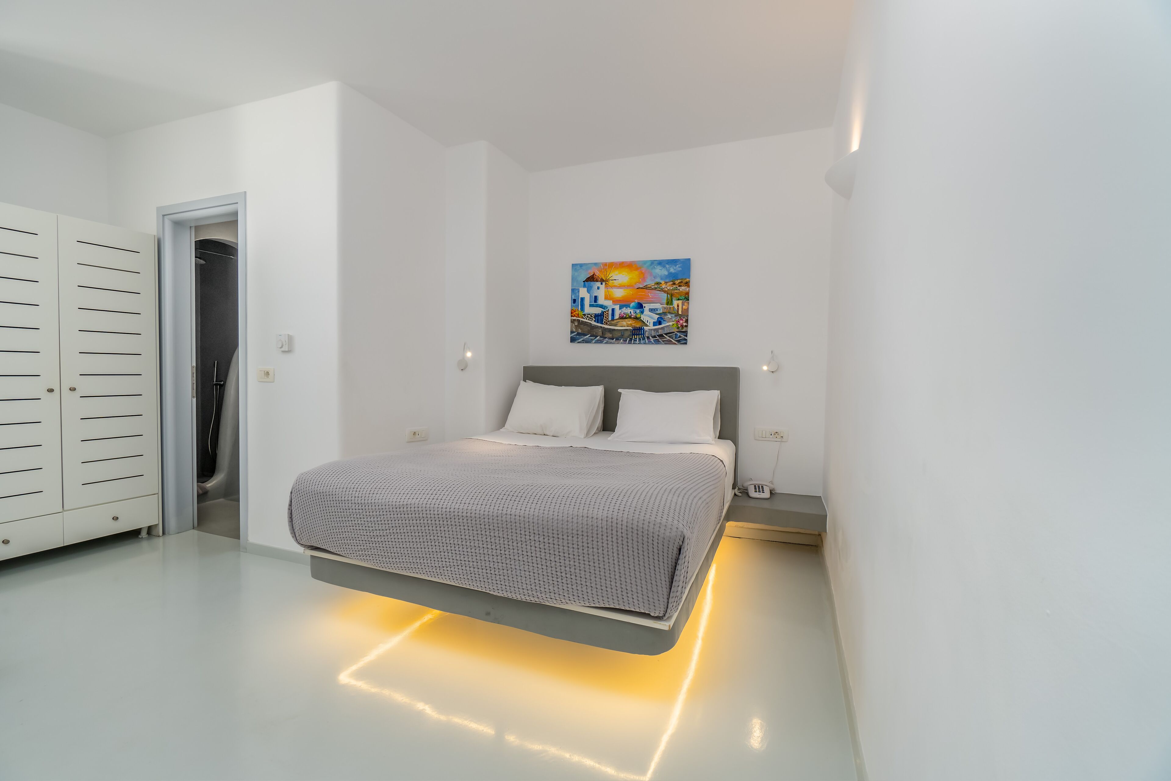 Une chambre à coucher moderne avec un lit, un tableau au mur et une armoire.