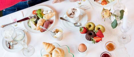 A table set with various breakfast items including pastries, fruits, and beverages.