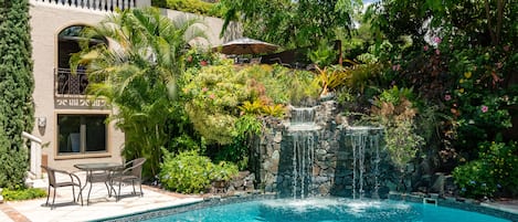 Una piscina al aire libre, sillones reclinables de piscina