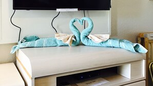 A hotel room with a flat-screen TV mounted above a wooden desk. - Apollo Inn Motel (Cocoa)