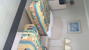 A hotel room with two beds, a bedside table, a nightstand, a lamp, and a framed picture on the wall. - Apollo Inn Motel (Cocoa)