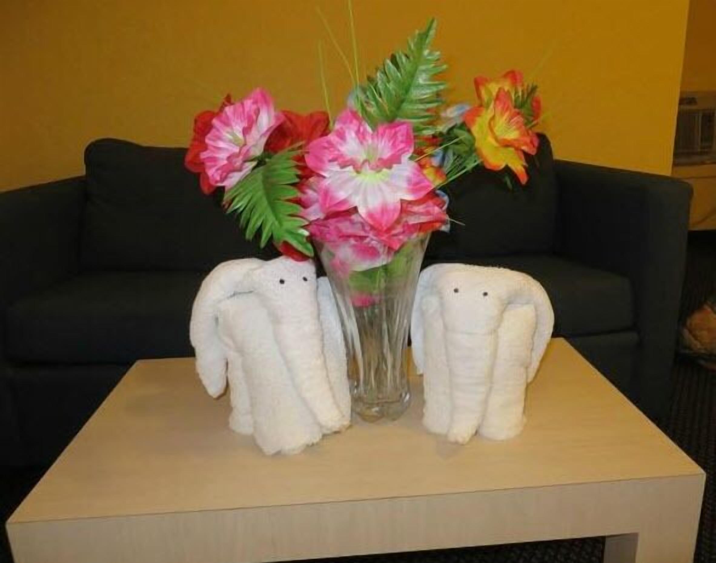 Ein Tisch mit einer Blumenvase und zwei weißen Stofftieren.
