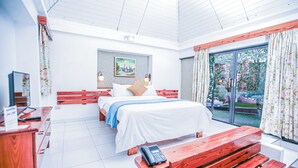 A hotel room with a bed, a desk, a telephone, and a bench. - Visa Lodge (Port-au-Prince)
