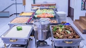 A buffet with various food options including rice, meat dishes, salads, and other prepared foods. - Visa Lodge (Port-au-Prince)