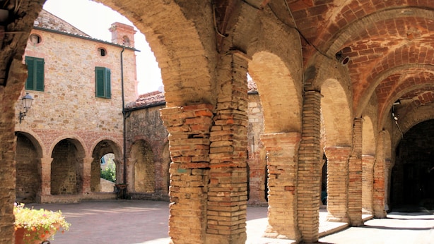 An ancient stone building with arched walkways and a courtyard. - La Fonte degli Angeli (Suvereto)