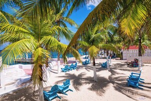 Na praia, espreguiçadeiras, guarda-sóis, toalhas de praia 