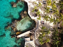 Na praia, espreguiçadeiras, guarda-sóis, toalhas de praia 