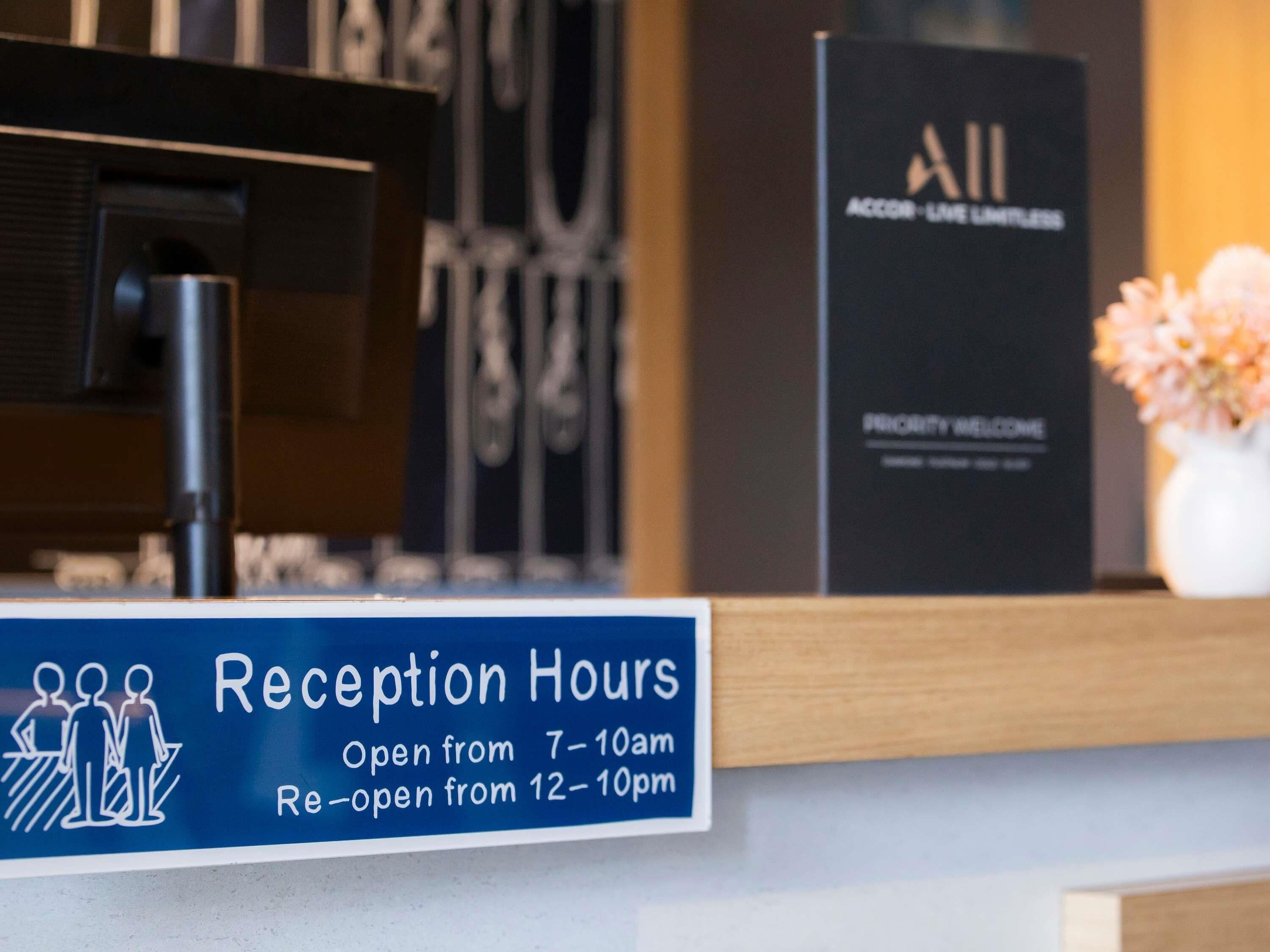 A reception desk with a sign indicating reception hours.