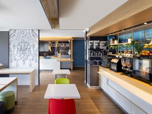 A modern reception area with a reception desk, seating area, and a coffee station. - ibis budget Casula Liverpool (Casula)