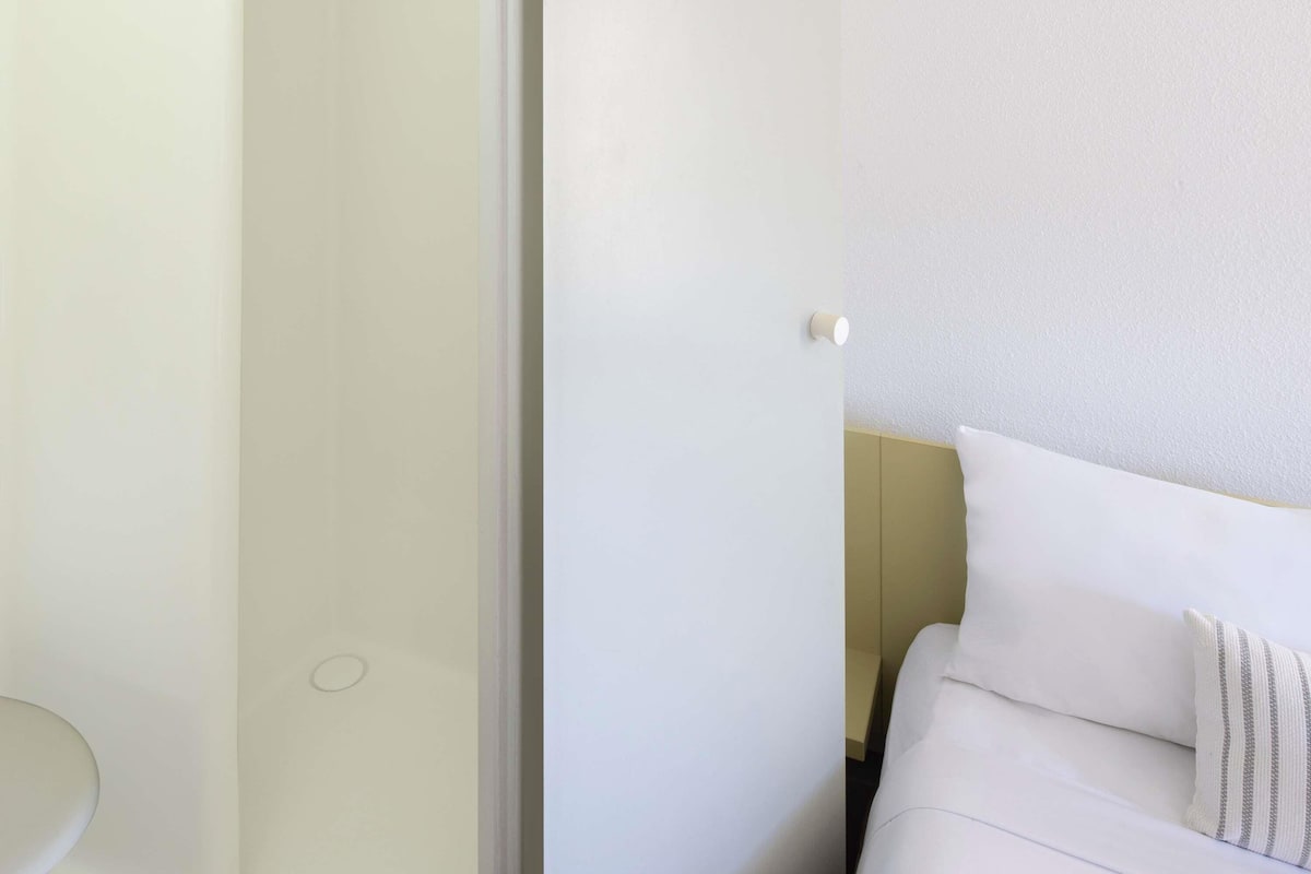 A white door with a light switch and a towel rack.