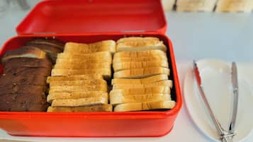 A red container with sliced bread and a loaf of bread.