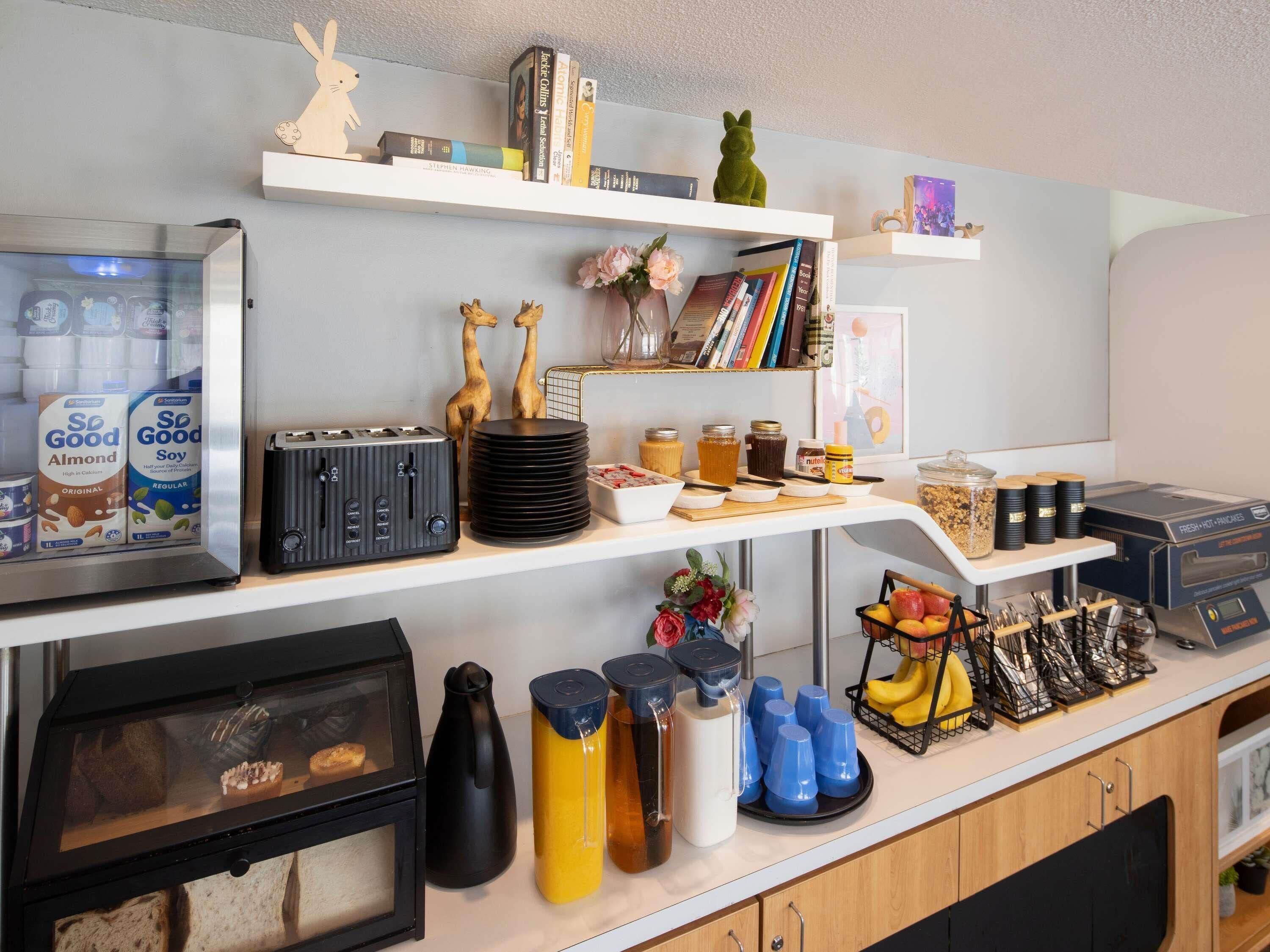 A kitchen counter with a refrigerator, toaster, and various food items.