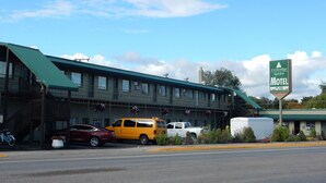 A motel with a green roof, multiple windows, and a sign indicating it is a value stay motel. - Citilodge Suites (Missoula)