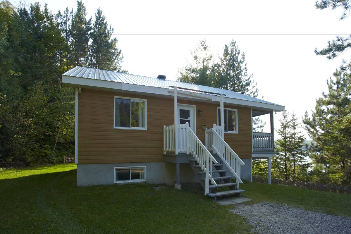 A single-story house with a front porch and a small staircase leading to a deck.