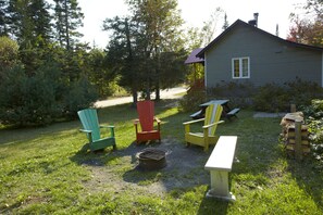 A rustic cabin with a gravel path leading to a wooden deck. - Chalets Lanaudiere (Rawdon)