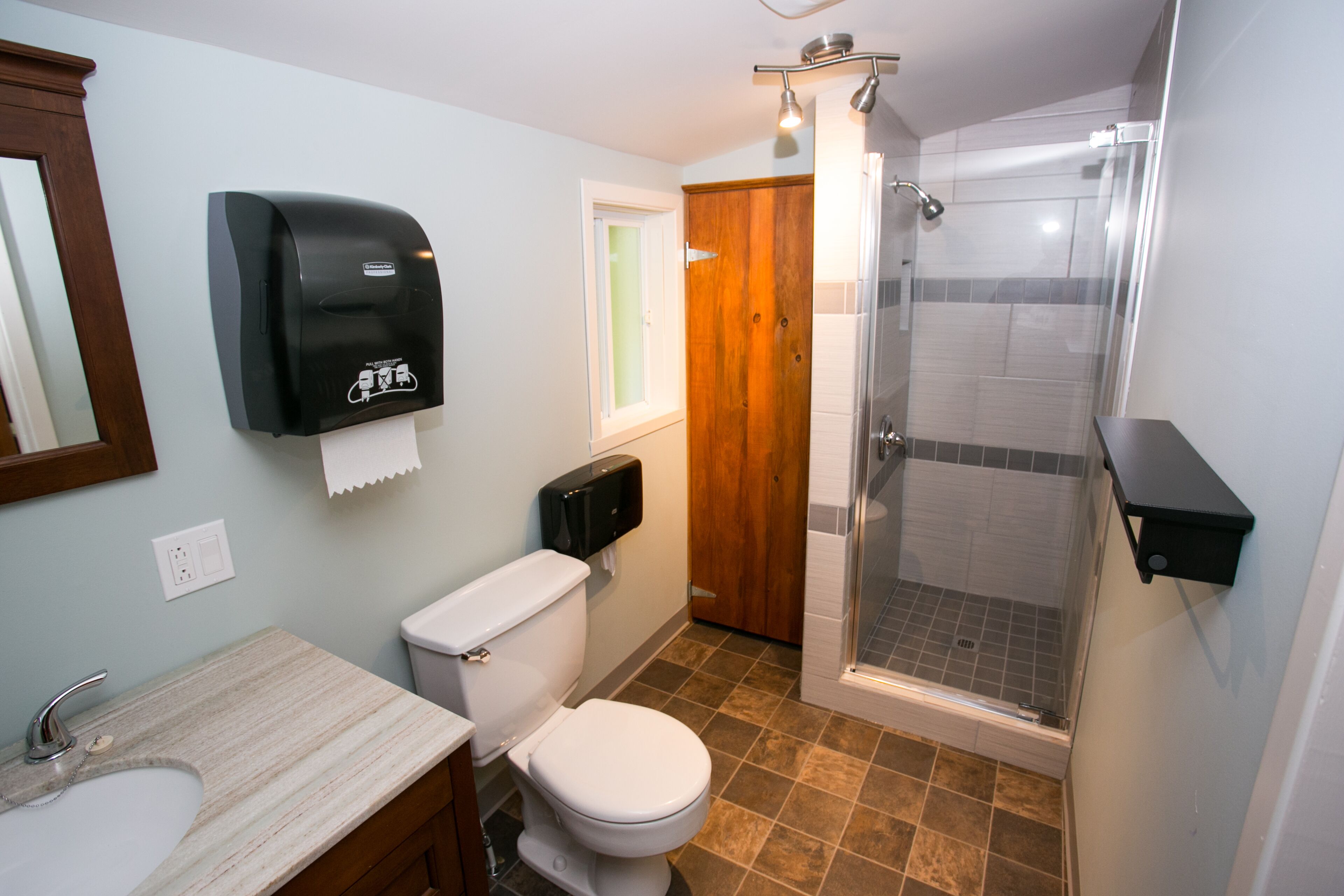 Un bagno con il water, un lavandino e una cabina doccia in vetro.